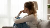Upset woman sitting on couch alone at home
