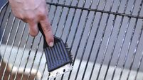 cleaning the grill with scrubber - Grillbürste