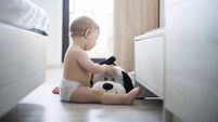 Baby boy playing with stuufed toy at home.