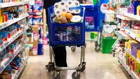 Full shopping cart, customer is stocking vital needs because of global chaos. Shopping with blur supermarket store products, int