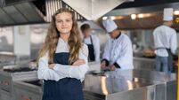 Portrait of student girl chef wearing apron standing with crossed arms study cooking class in kitchen at school