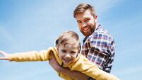 Father and his little son playing together in a park