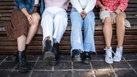 Low section of young friends sitting on a bench