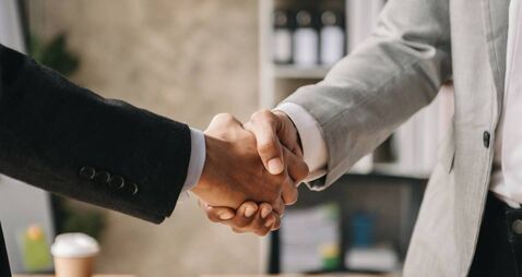 Two confident business man shaking hands during a meeting in the office, success, dealing, greeting and partner in sun light