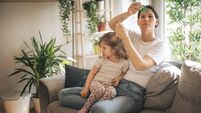 Mother doing head lice cleaning on daughter