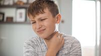 Sore Throat - Boy holding his neck in pain