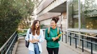 University student girl friends with learning books walking out School building