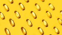 Yellow oval pills capsules vitamin Omega 3 over yellow