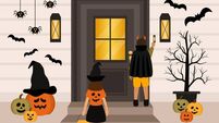 Rear View Of Children In Halloween Costumes Going Trick Or Treat. Little Boy Ringing The Doorbell Of The House Decorated For Hal