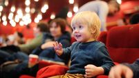Cute toddler boy watching cartoon movie in the cinema