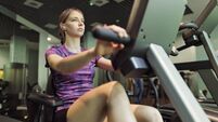 Teenage girl working out on exercise bike in a gym