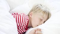 Boy sleeping in bed with crisp white sheets