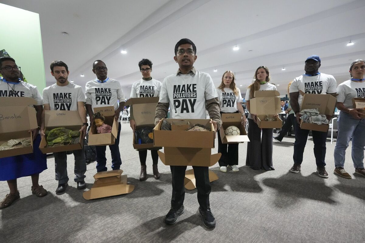 Demonstrators hold items that were recovered by support teams from extreme weather events and displayed at Cop29 on Monday. Photo: AP/Sergei Grits Demonstrators hold items that were recovered by support teams from extreme weather events and displayed at Cop29 on Monday. Photo: AP/Sergei Grits