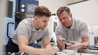 Engineer Showing Apprentice How To Measure CAD Drawings