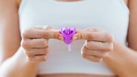 Young woman hands folding a menstrual cup.