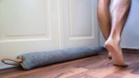 Person Walking Barefoot Near Draft Excluder Under Door