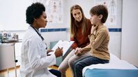 Little boy complaining of a sore throat during medical appointment at pediatrician's.