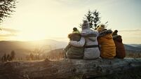 Mother and kids enjoying sunset in mountains