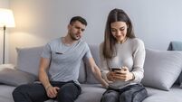 Man spying his girlfriend mobile phone.