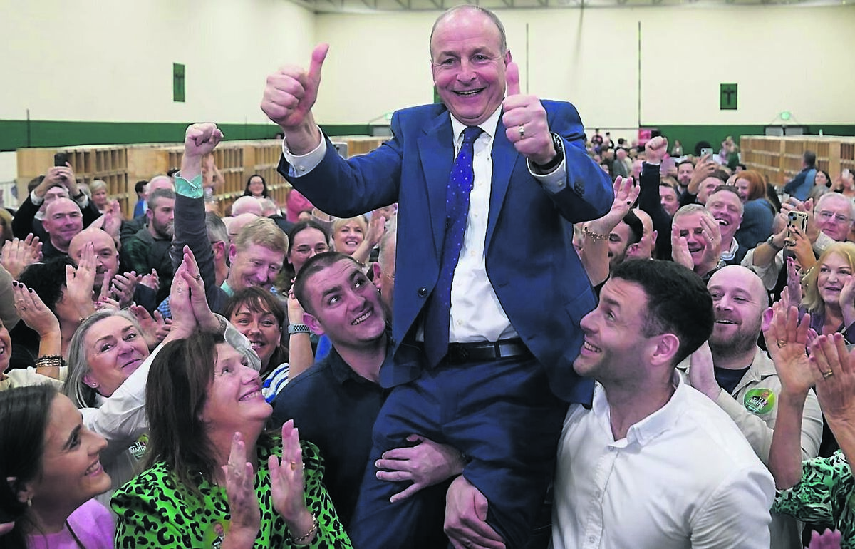 Fianna Fáil leader Micheál Martin is hoisted by sons Cillian and Micheal Aodh, on being elected in  Cork South Centra at Nemo Rangers GAA Club.