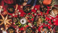 Flat-lay of friends eating and talking at festive Christmas table