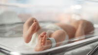 Cute Little Caucasian Newborn Baby Lying in Bassinet in a Maternity Hospital. Portrait of a Tiny Playful and Energetic Child wit
