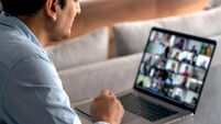 Man in a video conference with his team. Working at home with a laptop.